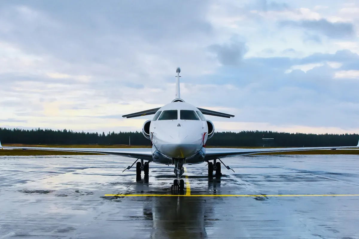 Business jet on a wet ramp under a cloudy sky
