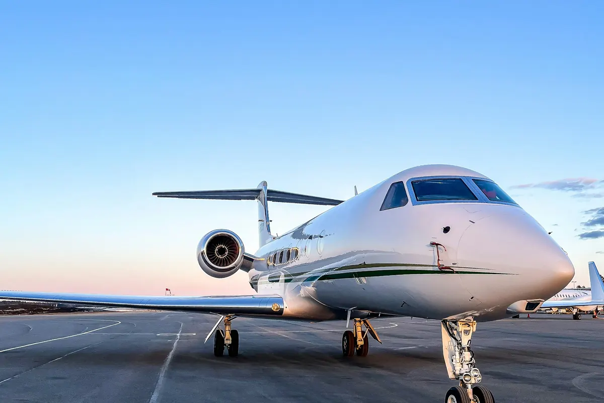 Business jet parked on a ramp at sunset
