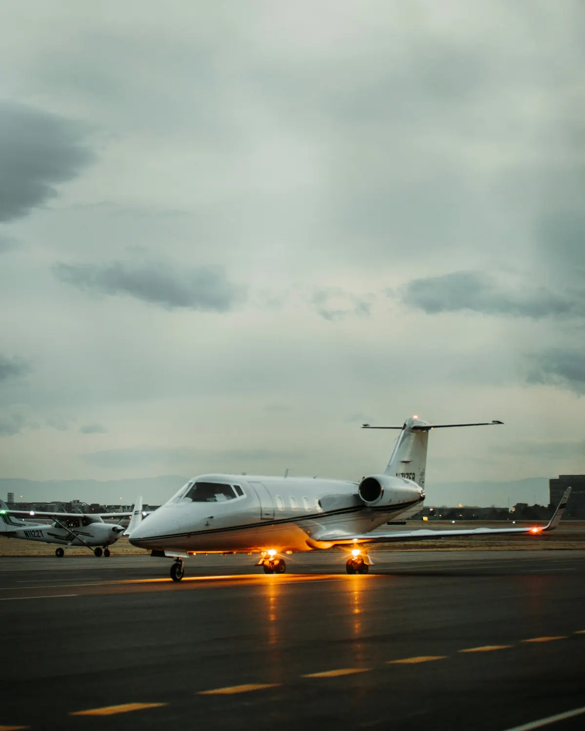 Business jet waiting on a runway under a moody sky