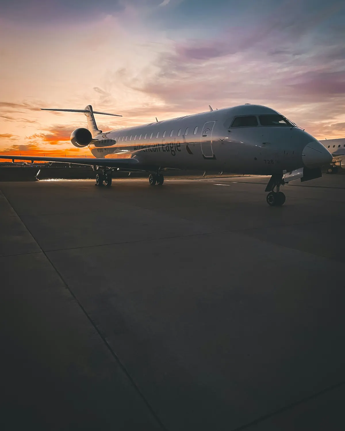 Private jet on the ramp at dusk with its cabin lights on