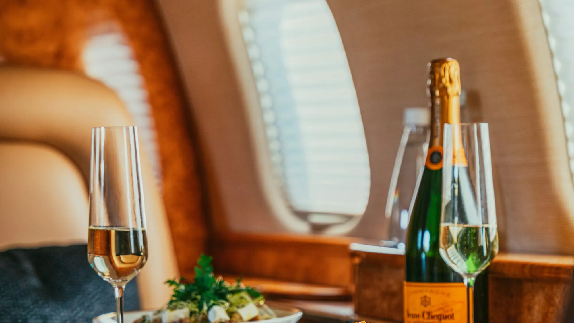Champagne and a meal set at a private jet window table